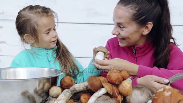 Moeder en dochter schone vers geplukt paddestoelen. Portret van een moeder met haar kind voor het reinigen van ecologisch schoon voedsel. Eten, koken, milieuvriendelijkheid. — Stockvideo