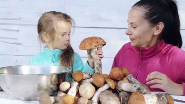 Mutter und Tochter säubern frisch gepflückte Pilze. Porträt einer Mutter mit ihrem Kind bei der Reinigung ökologisch sauberer Lebensmittel. Essen, Kochen, Umweltfreundlichkeit. — Stockvideo