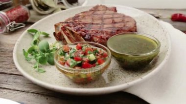 Biftek ve bir plaka üzerinde baharat kompozisyonu. Sığır eti biftek güzel restoranda dekore edilmiştir. Doğru kızarmış biftek soslar. 