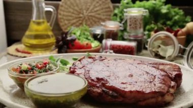 Biftek ve bir plaka üzerinde baharat kompozisyonu. Sığır eti biftek güzel restoranda dekore edilmiştir. Doğru kızarmış biftek soslar. 