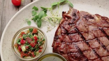 Biftek ve bir plaka üzerinde baharat kompozisyonu. Sığır eti biftek güzel restoranda dekore edilmiştir. Doğru kızarmış biftek soslar. 