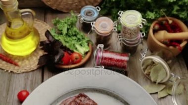 Biftek ve bir plaka üzerinde baharat kompozisyonu. Sığır eti biftek güzel restoranda dekore edilmiştir. Doğru kızarmış biftek soslar. 