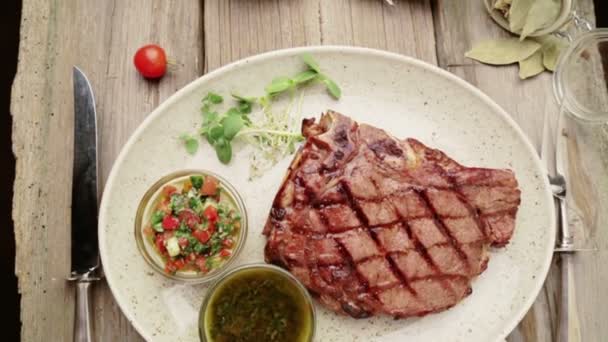 Biftek ve bir plaka üzerinde baharat kompozisyonu. Sığır eti biftek güzel restoranda dekore edilmiştir. Doğru kızarmış biftek soslar. — Stok video