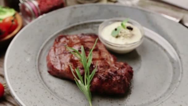 Složení s steak a koření na talíři. Hovězí steak je krásně zdobené v restauraci. Správně smažený steak omáčky. — Stock video