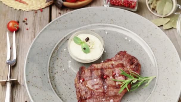 Composition avec steak et épices dans une assiette. Le steak de bœuf est magnifiquement décoré dans le restaurant. Steak correctement frit avec sauces . — Video