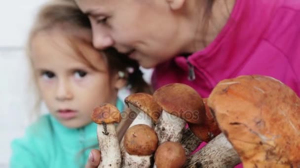 Mãe e filha limpas cogumelos recém-colhidos. Retrato de uma mãe com seu filho para limpar alimentos ecologicamente limpos. Comida, culinária, respeito pelo meio ambiente . — Vídeo de Stock