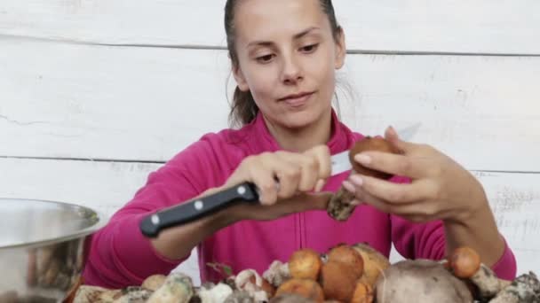 Young beautiful woman cleaning fresh mushrooms. Portrait of a young chef girl preparing mushrooms. A natural, eco friendly kitchen. — Stock Video