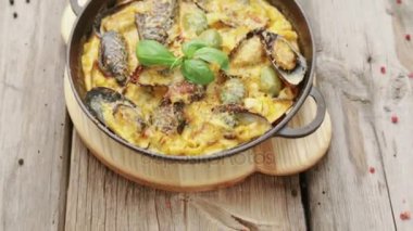 Baharat ahşap bir zemin üzerine peynir soslu midye çanağı. Midye bir Barbekü ortasında pişmiş peynirli.