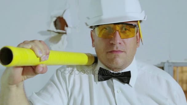 A jelentéskészítő a sledgehammer és a ceruza megy a kamera. Egy ember egy építkezésen egy építő. — Stock videók