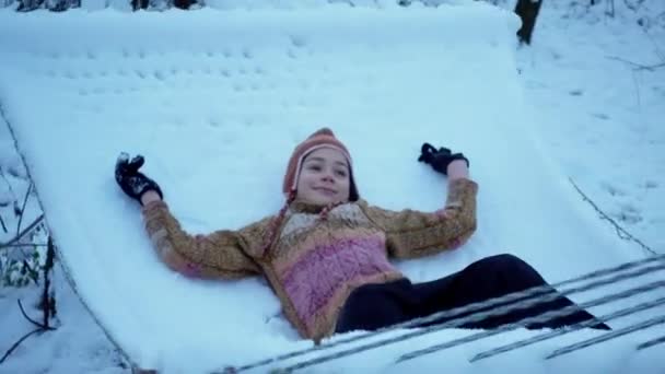 ハンモックに近い再生冬少年の肖像画 子供が遊ぶハンモック冬季の屋外 — ストック動画