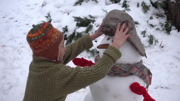 소년은 정원에서 눈사람을 있습니다 공원에는 겨울에 Sculpts 눈사람 — 비디오