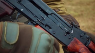 Bir askerin el ak 47 ile yakın çekim Kalaşnikof, video bir dizi ağır çekim dosyaları.