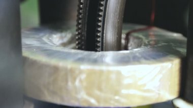Bir uzmanın elleri trafonun üretim sürecini kontrol eder. Üretim sürecinde trafo bobini. 