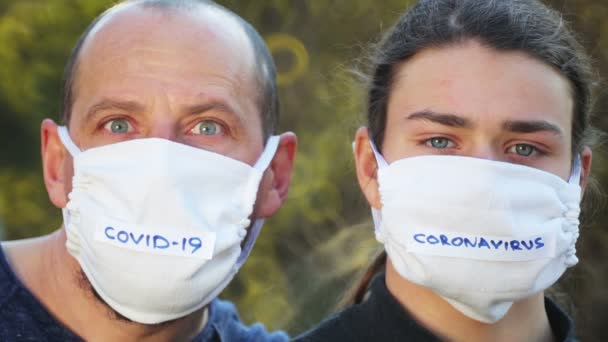 一个戴着防毒面具的男人和青少年的画像 父亲和儿子戴着医疗面具 — 图库视频影像