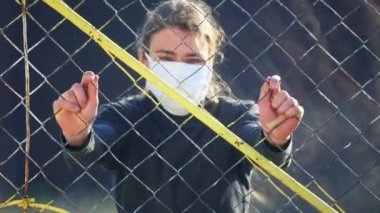 Karantina altındaki çocuk toplumdan izole edilmiş. Ağın arkasında izole edilmiş hasta bir gencin portresi.. 