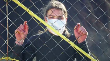 Karantina altındaki çocuk toplumdan izole edilmiş. Virüslü bir gencin portresi, bir ağ arkasında izole edilmiş, video dosyaları..