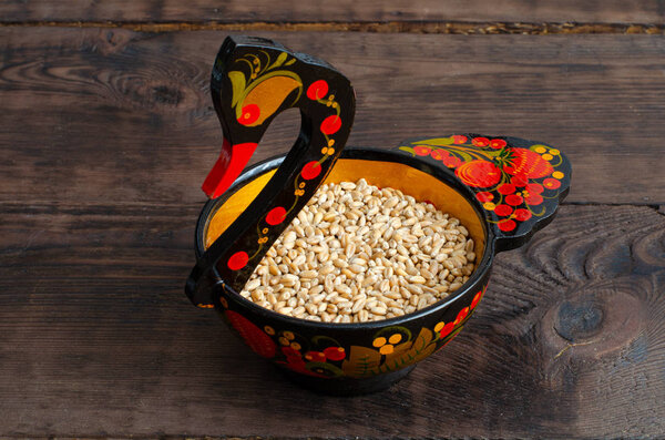 Clean wheat in wooden painted swan on wooden background
