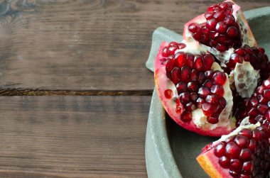 Tahta arkaplanda beton çanak üzerine kopyalama alanı ile granatum açıldı.