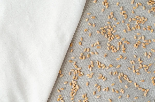 Clean wheat on linen background with copy space. Two types of linen. Cloth background. Fabric. Top view