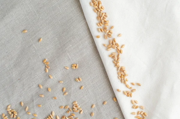 Clean wheat on linen background with copy space. Two types of linen. Cloth background. Fabric. Top view