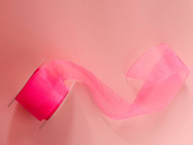 Pembe arka planda pembe kapron kurdelesi. Pembe çizgili. Üst görünüm.