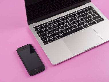 Laptop çalışma ofisinde pembe arka plan üzerinde 