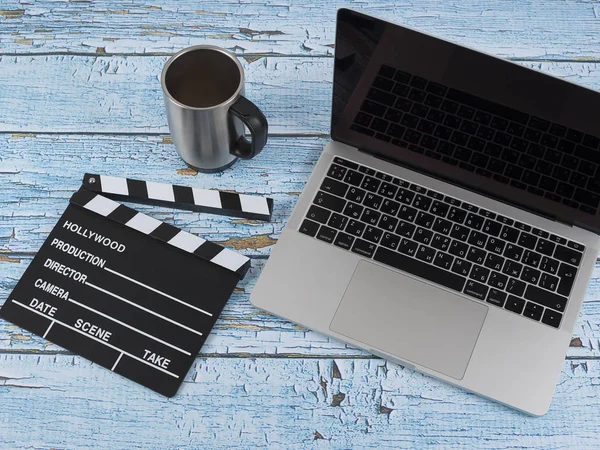 Taza de café con computadora portátil y teléfono celular y película clapper en madera —  Fotos de Stock