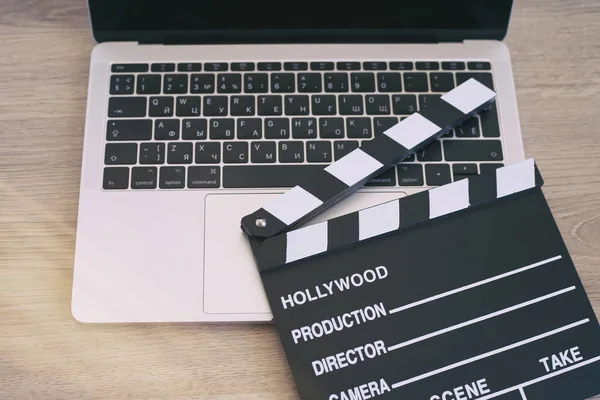 Film clapper ve ahşap masa üstünde laptop 