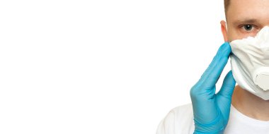 Lateks koruyucu eldivenli genç cerrah beyaz arka plana beyaz koruma maskesi takıyor. Tıbbi eldivenli ve koruyucu maskeli bir adam. Coronavirus COVID-19 koruması
