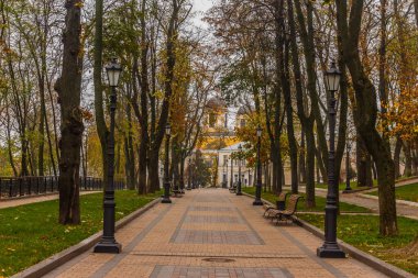 Kiev, Ukrayna - 27 Ekim 2019: Kiev parkında sonbahar. Vladimir Anıtı, Vladimir parkındaki sarı ağaç yaprakları ve kentsel Volodymyrska Tepesi 'ndeki Dinyeper Nehri manzarası boyunca uzanır.