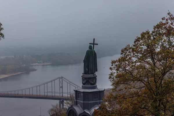 Kiev, Ukrayna - 27 Ekim 2019: Kiev parkında sonbahar. Vladimir Anıtı, Vladimir parkındaki sarı ağaç yaprakları ve kentsel Volodymyrska Tepesi 'ndeki Dinyeper Nehri manzarası boyunca uzanır.
