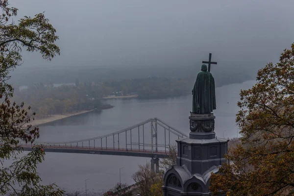 Kiev, Ukraina - 27 oktober 2019: Hösten i Kiev park. Sankt Vladimir Monument utsikt genom gula träd lövverk i Vladimir park och utsikt över floden Dnepr i stadsparken Volodymyrska Hill — Stockfoto