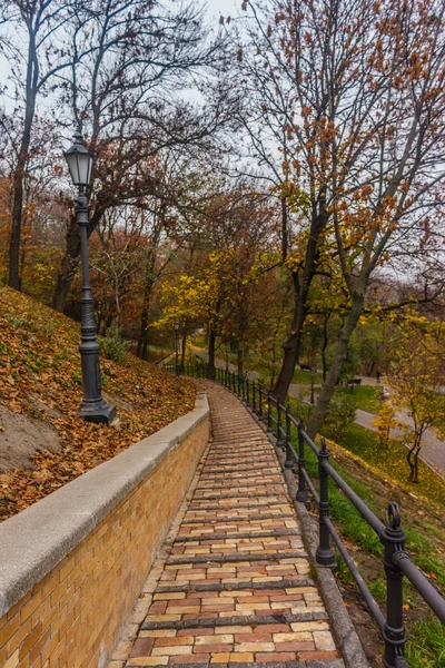 KIEV, UKRAINE - Oktober 27 2019: Autumn in Kiev park. Saint Vladimir Monument view through yellow tree foliage in Vladimir park and view of Dnieper River in urban park Volodymyrska Hill