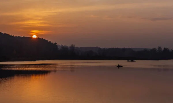 Gölde gün batımı. Balık tutmaya. Balıkçı. Kiev bölgesi. Ukrayna.