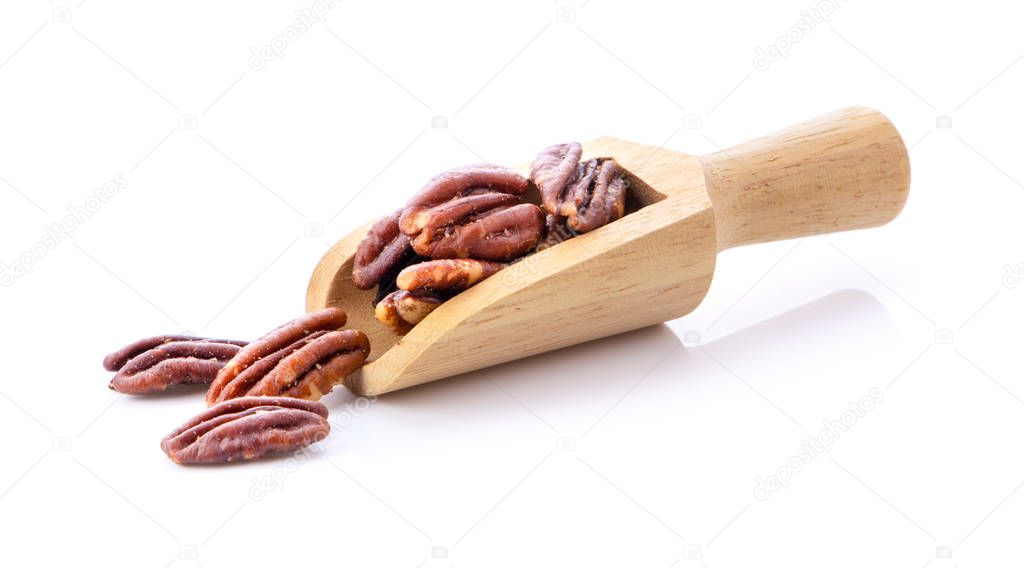 Pecan nuts topped with light salt in wood scoop  isolated  on white background