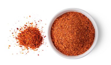 Kırılmış kırmızı biber beyaz arka planda beyaz kasede. en üstteki görünüm