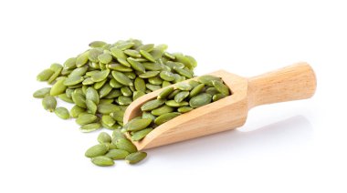 Beyaz arka planda izole edilmiş odun kepçesindeki kabak tohumları. tam alan derinliği