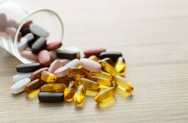 Küçük bardaktan Fishoil kapsülleri ve Multivitamin takviyeleri