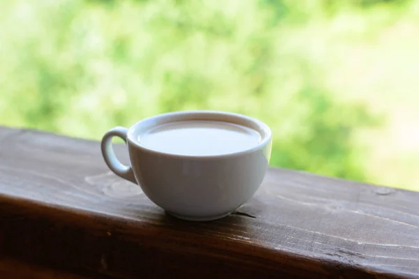 Taza de café con leche en una mesa de madera —  Fotos de Stock