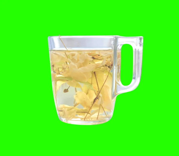 Стеклянная чашка с варёным липовым чаем изолирована на зелёном — стоковое фото