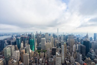 Empire State binasının tepesinden bulutlarla Manhattan ufuk çizgisini görüntüle