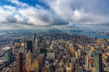 Empire State binasının tepesinden bulutlarla Manhattan ufuk çizgisini görüntüle