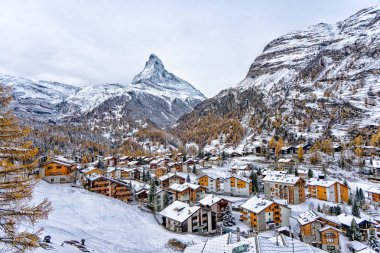 View of Matterhorn mountain with typical Swiss village Zermatt in the foreground clipart