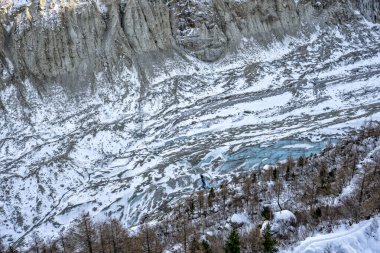 Visiters enterning ice cave under massive glacier near Chamonix in French Alps