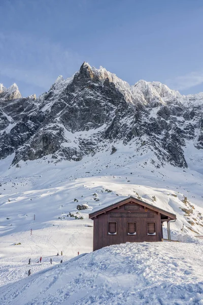 Aiguille du Plan前の雪の斜面に暗い木造住宅 — ストック写真