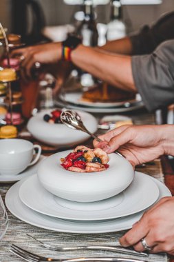 Porselen bir tabak meyve salatasının üzerine bir kuponla elini kapat.