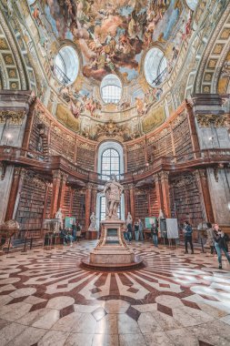 Viyana, Avusturya - 28 Nisan 2019: Ziyaretçiler İmparator Chalres Vi 'nin etrafındaki imparatorluk kütüphanesinin tavanına hayran kaldılar