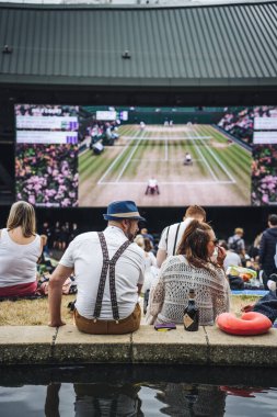 Wimbledon, Uk - 14 Temmuz 2019: Bir beyefendi ve bir bayan erkekler finalinden önce Wimbledon 'da açık hava ekranının önünde oturuyorlar