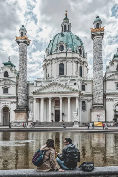 Wenen, Oostenrijk - 28 april 2019: Liefhebbers zitten bij de fontein voor Karlskirch durring zonnige dag — Stockfoto