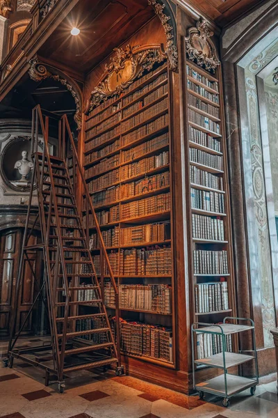 Viena, Austria - 28 de abril de 2019: Escaleras además de estantería antigua llena de libros antiguos dentro de la biblioteca imperial —  Fotos de Stock